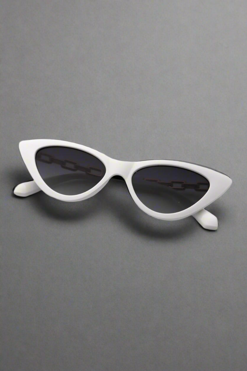 Red Vixen cat-eye sunglasses folded on a stylish mirror , radiating beauty and bold style.