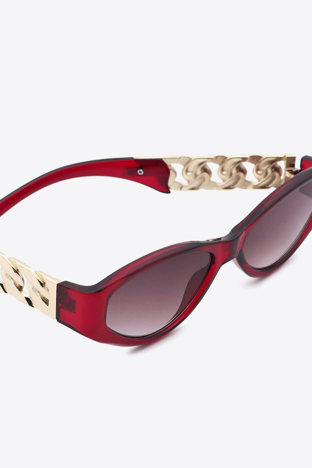 Close-up of NUVO red Rebel sunglasses resting on soft textured fabric—fierce design meets effortless elegance.