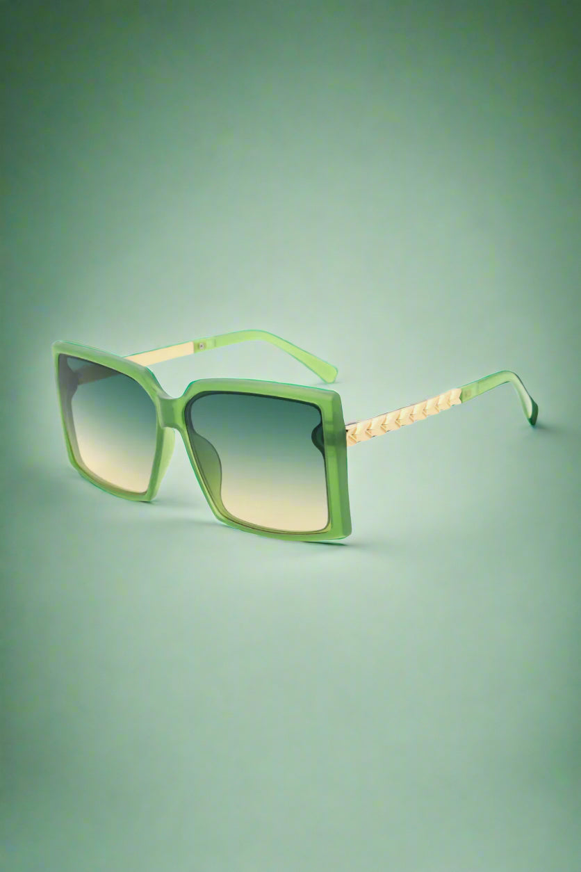 Green Vespa aviator sunglasses with a bold vintage edge, styled against a vibrant summer streetscape — where nostalgia meets confidence.